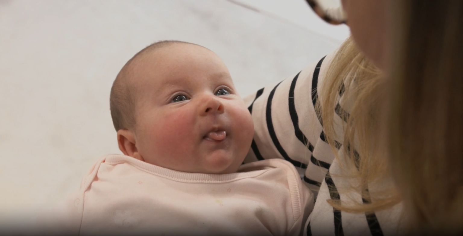 A baby looking up at their mother.