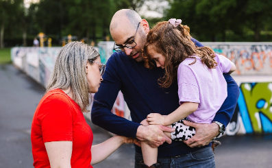 A mother and father tend to their daughters injured knee.