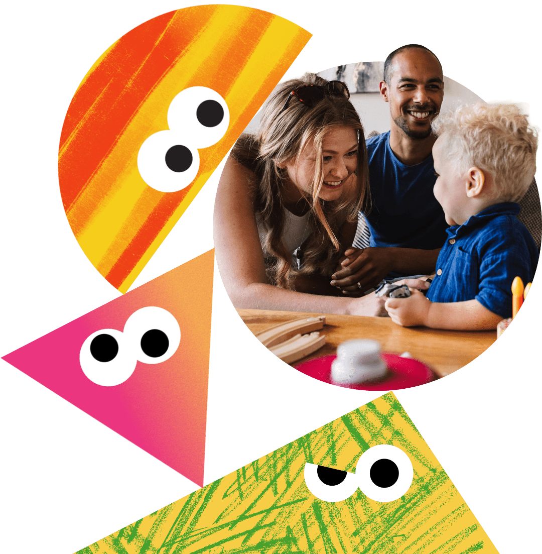 A mother and father laughing with their toddler.