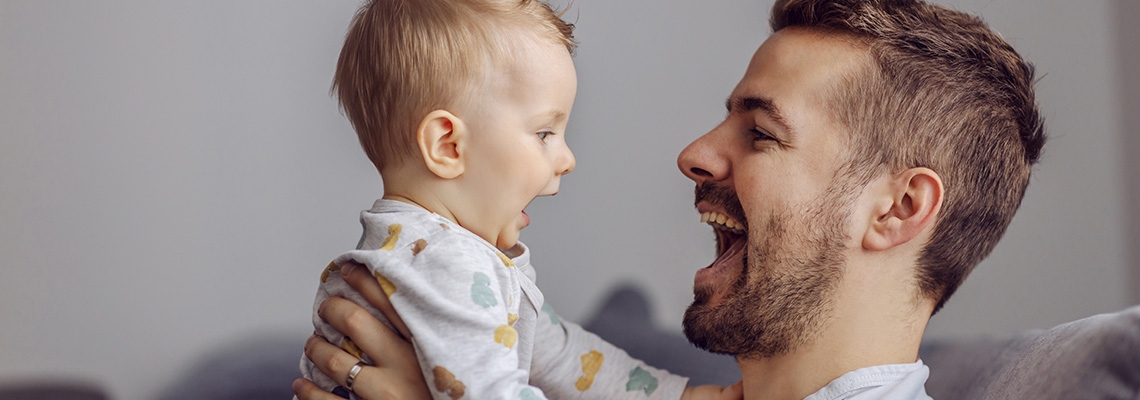 A father holding his infant baby.