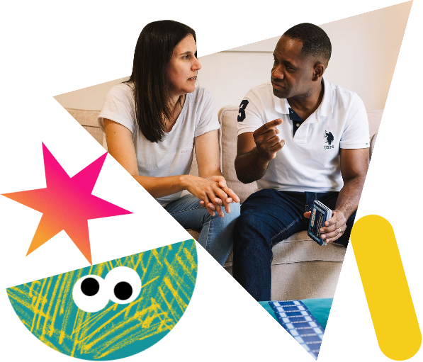 A couple sit on a sofa having a conversation.