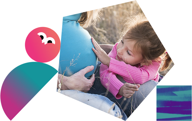 A young girl touching her mothers pregnancy bump.