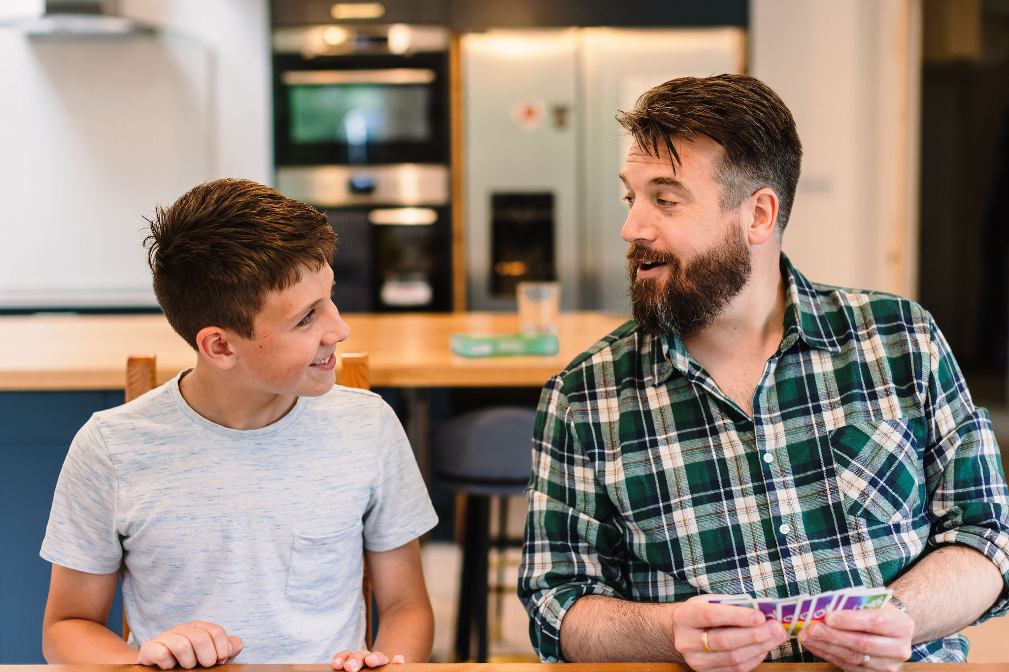 A father and son playing a card game together.
