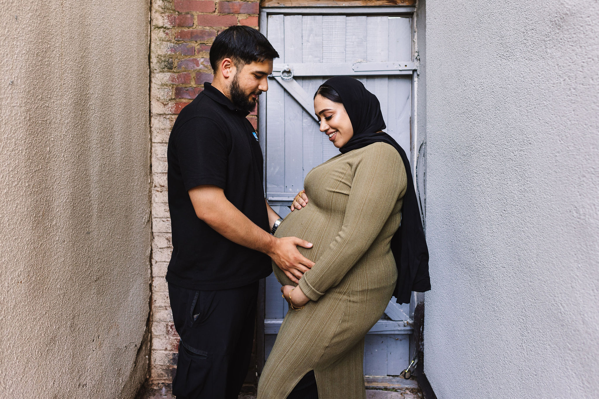A man holding the pregnancy bump of an expectant mother.