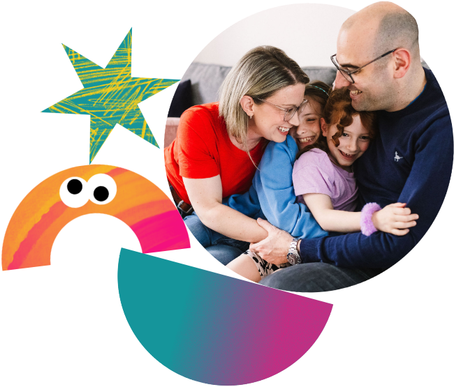 A mother and father hug their two daughters.