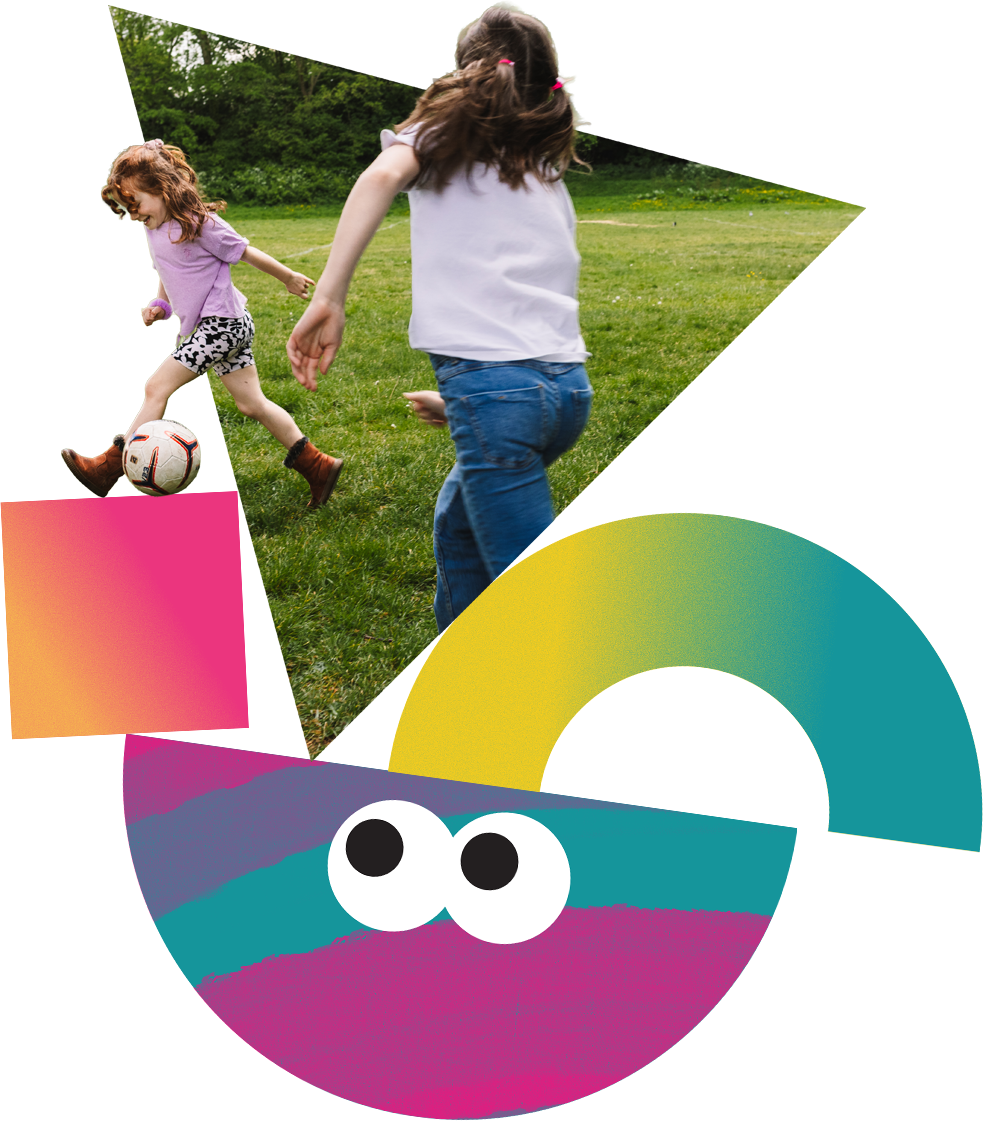 Two young sisters play football outside together.