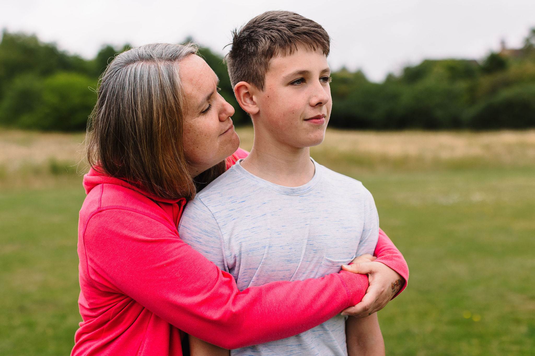 Mum hugging teenage boy.