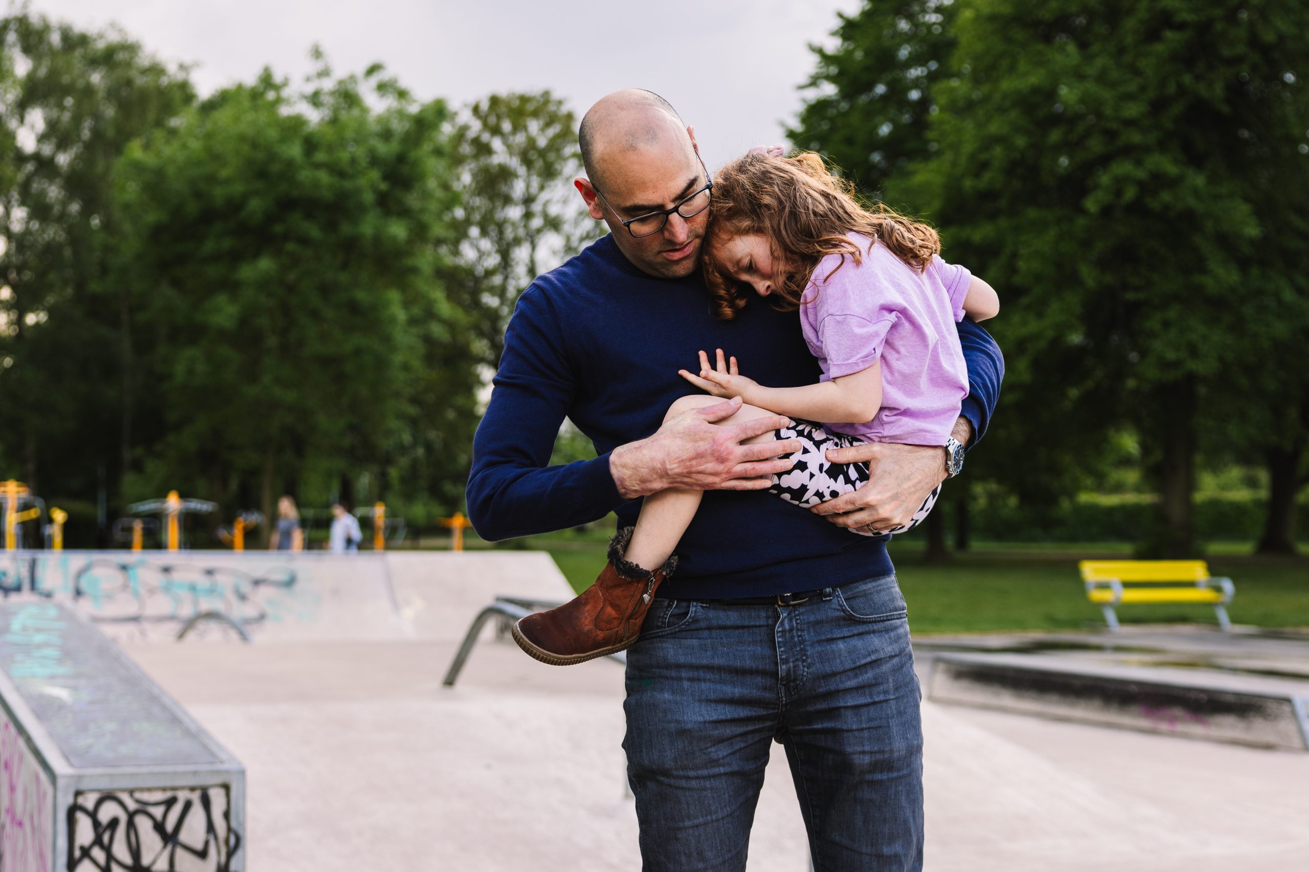 Dad comforting young daughter who has hurt her knee