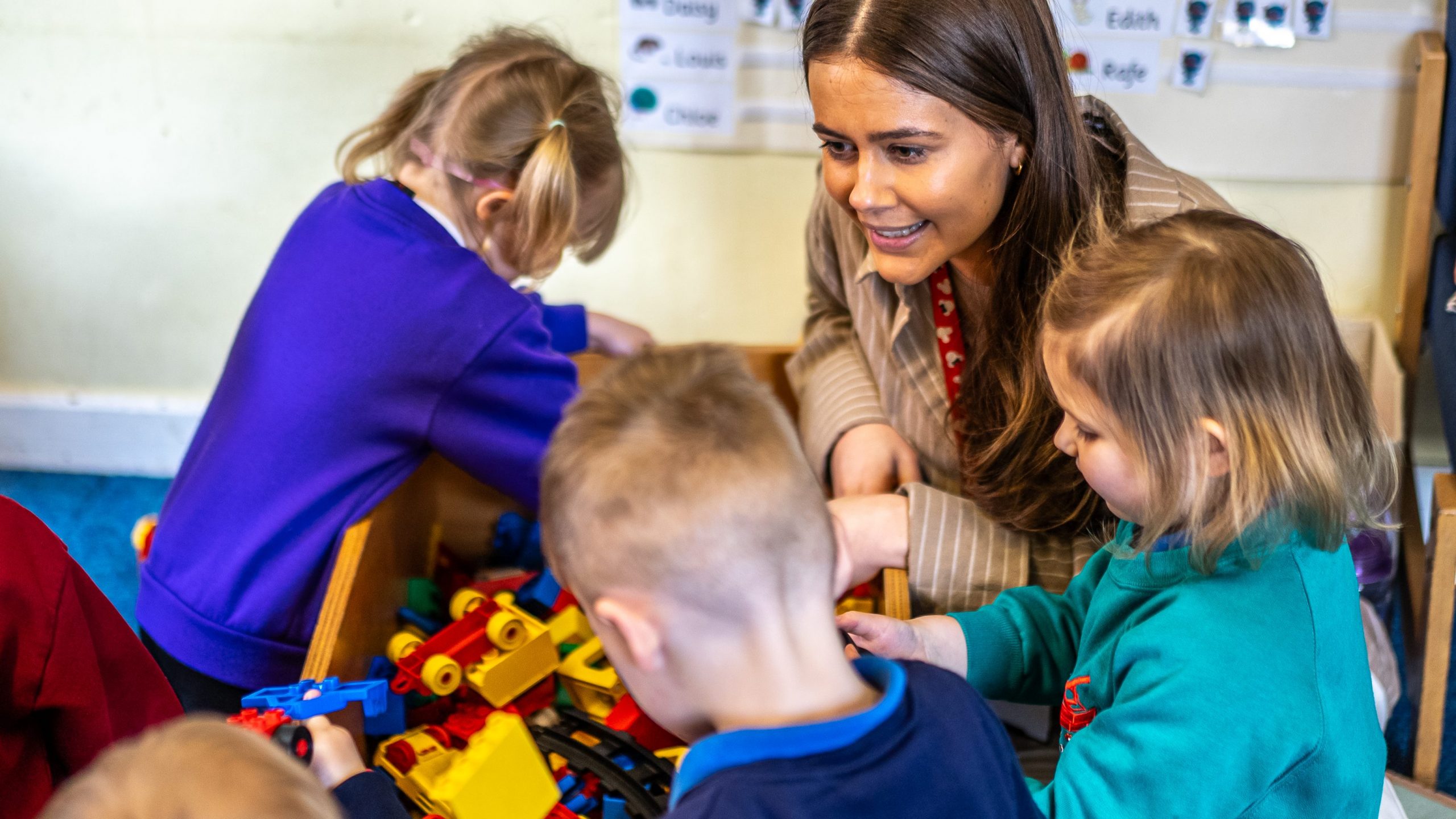 Teacher with children playing with lego