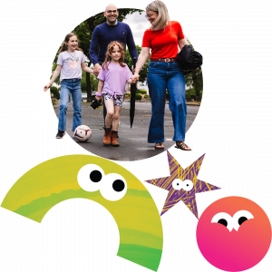 A family walking along the pavement with a football.