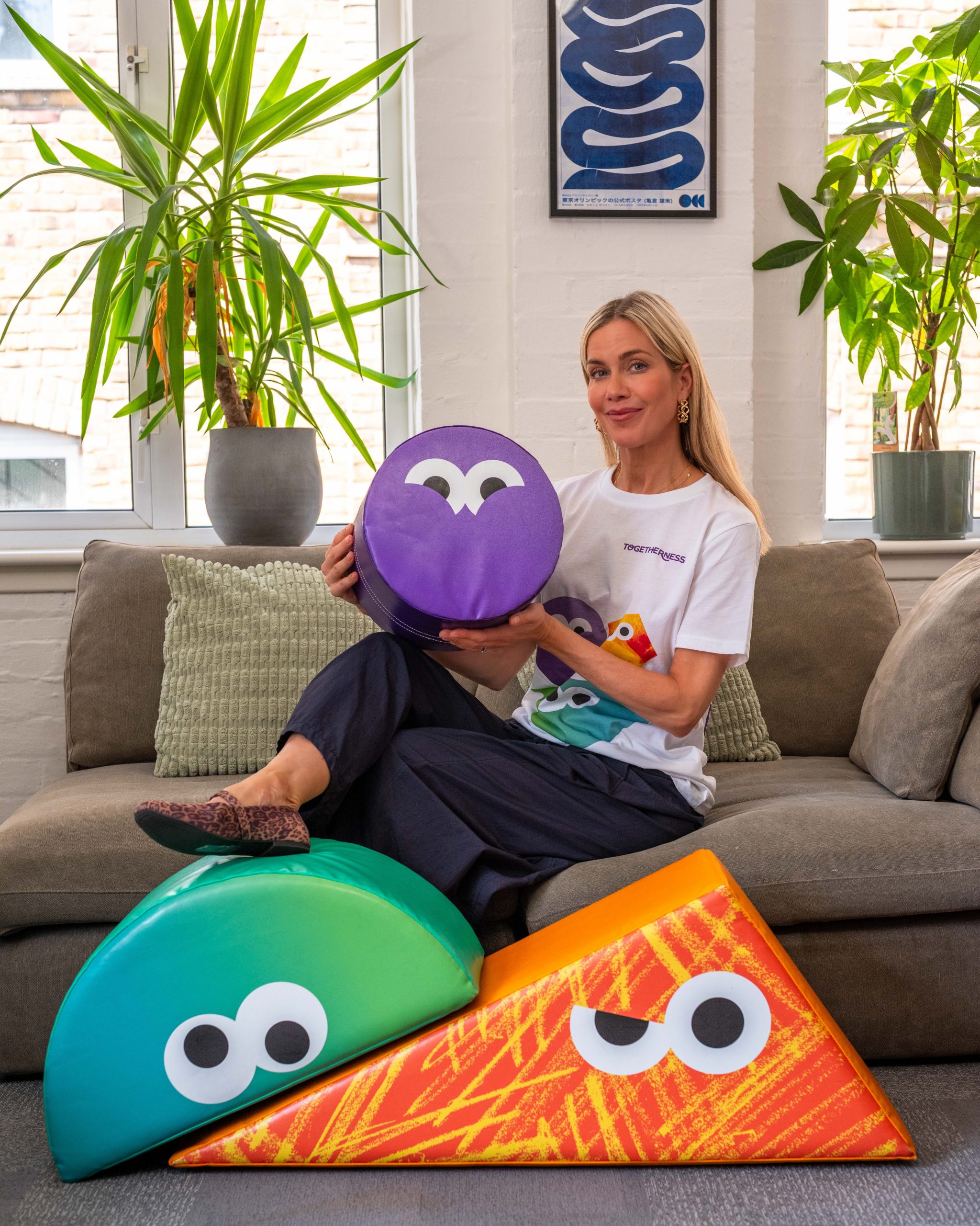 Kate Lawler sat on sofa with Togetherness soft play shapes