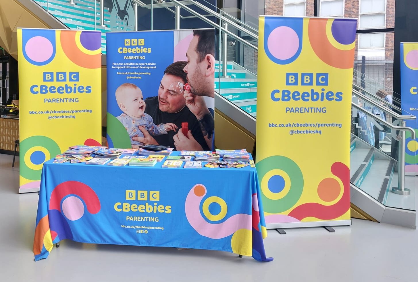 Three CBeebies Parenting pull up banners behind a table